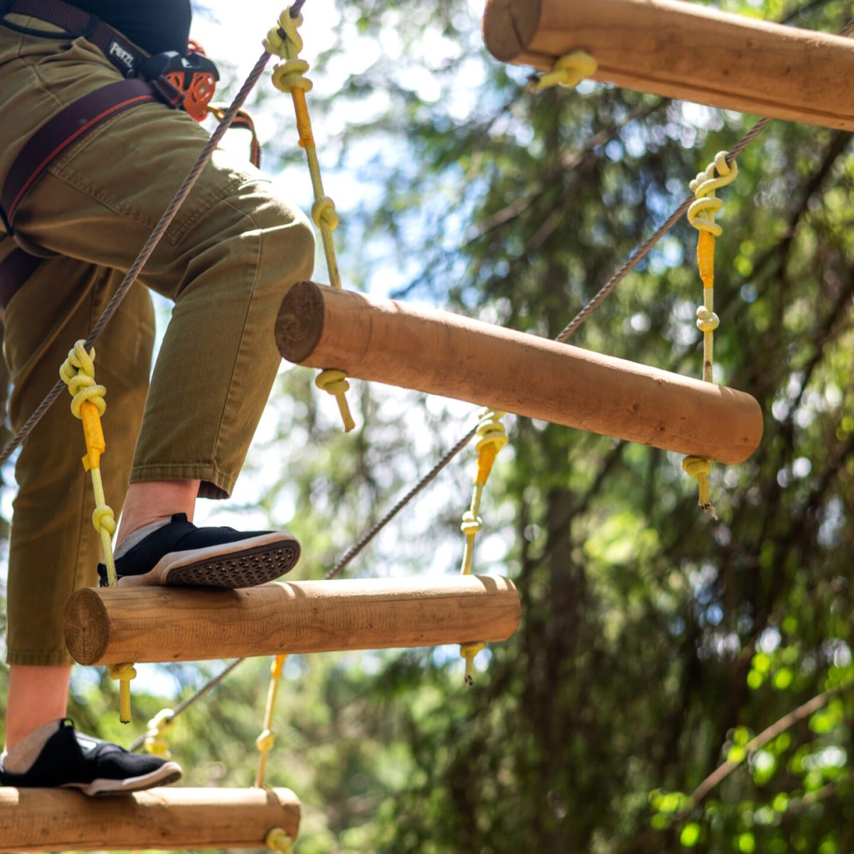 View of a woman at climbing adventure park in the Carpathians, greenery around, Romania